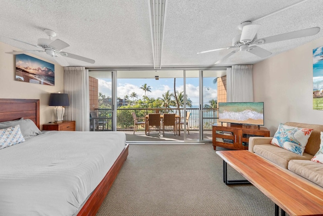 bedroom with access to exterior, ceiling fan, a wall of windows, carpet, and a textured ceiling