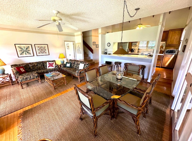 dining area with ceiling fan, a textured ceiling, and wood-type flooring