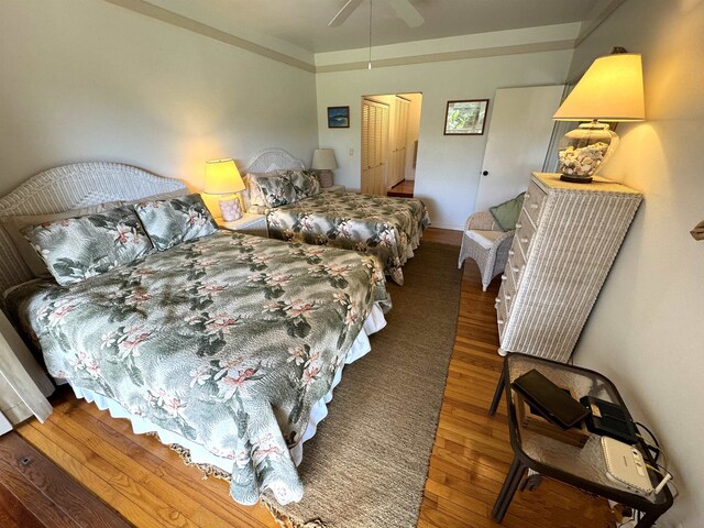 bedroom with ceiling fan, dark wood-type flooring, and crown molding