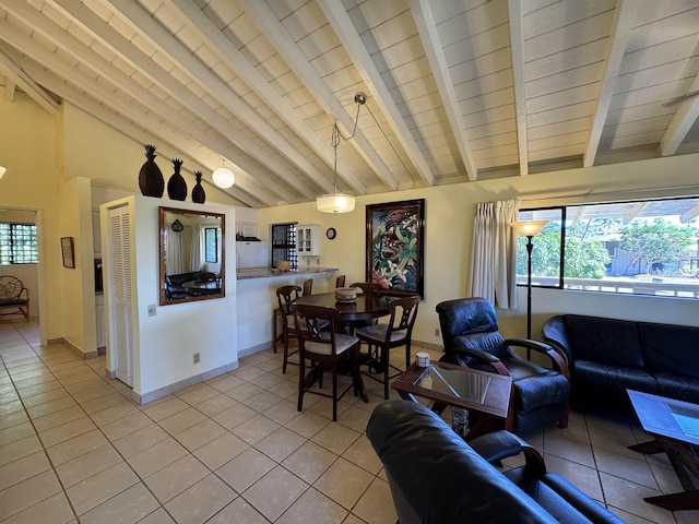 living room with vaulted ceiling with beams and light tile patterned floors