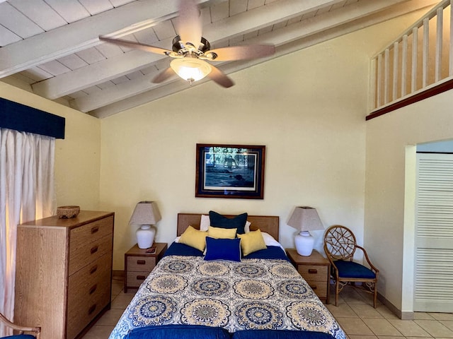 tiled bedroom featuring beamed ceiling and ceiling fan