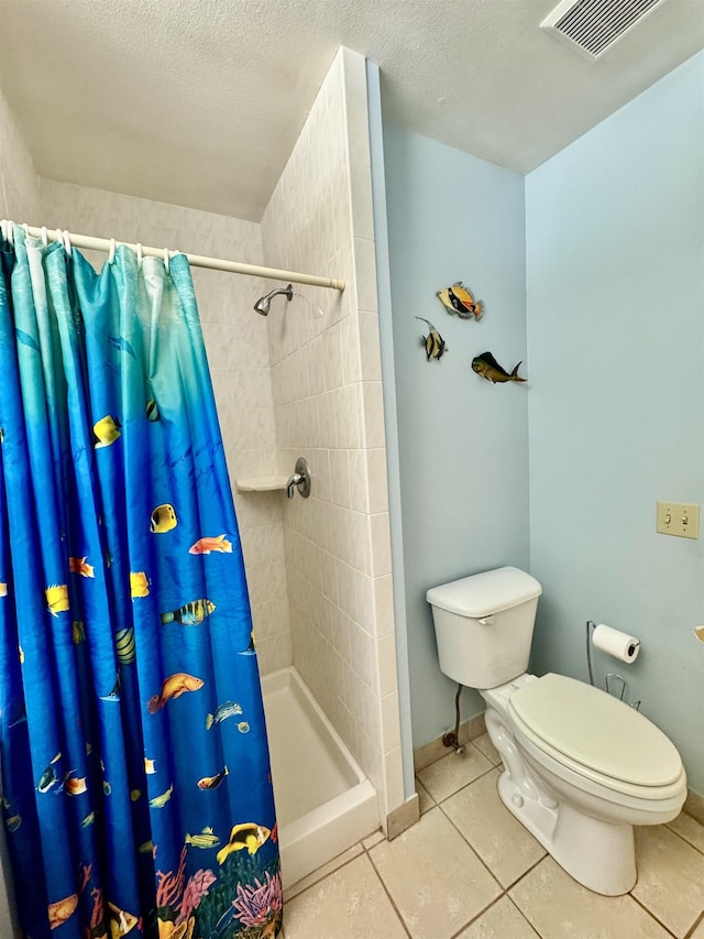 bathroom with tile patterned floors, toilet, curtained shower, and a textured ceiling