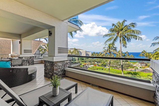 balcony featuring an outdoor living space and a water view