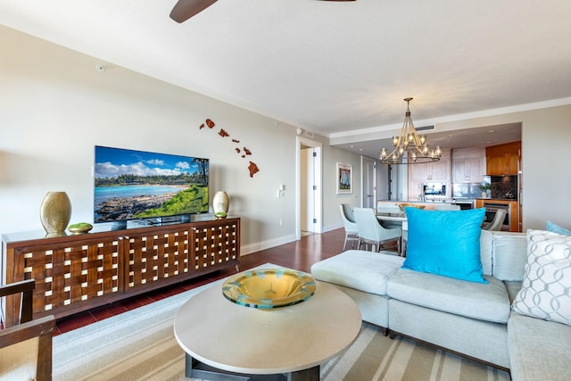 living room featuring a chandelier, baseboards, and wood finished floors