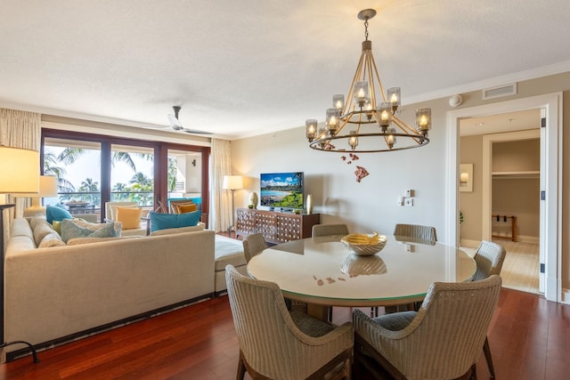 dining space featuring visible vents, a textured ceiling, dark wood-type flooring, and ornamental molding