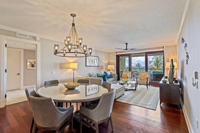 dining room with dark wood finished floors, a textured ceiling, and ornamental molding