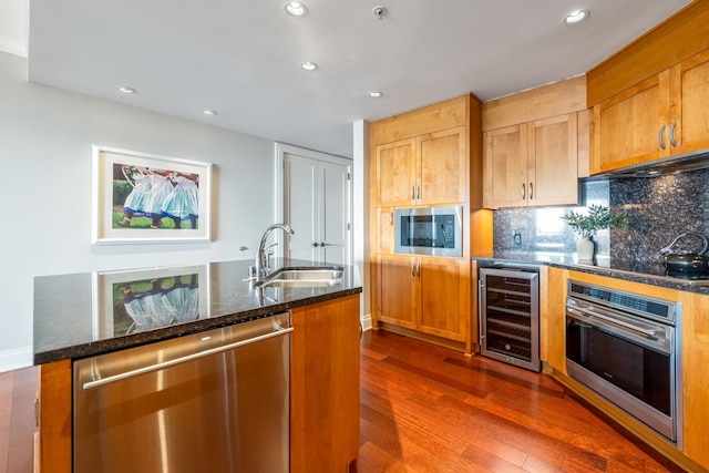 kitchen with backsplash, dark wood-type flooring, wine cooler, stainless steel appliances, and a sink