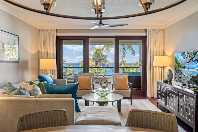 living area with a textured ceiling, wood finished floors, ceiling fan, and ornamental molding