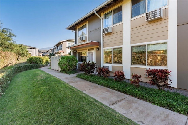 exterior space with cooling unit and a lawn