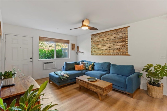 living room featuring light hardwood / wood-style flooring, an AC wall unit, and ceiling fan