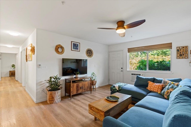 living room with a wall unit AC, ceiling fan, and light wood-type flooring