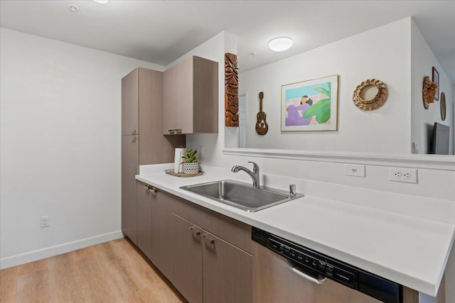 kitchen featuring stainless steel dishwasher, sink, and light hardwood / wood-style flooring