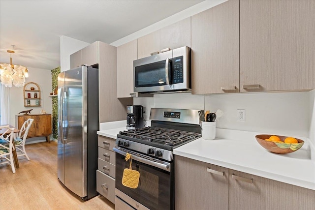 56 Kihalani St Unit 1203, Kihei, HI 96753 - kitchen with stainless steel appliances, light countertops, light wood-type flooring, and a chandelier