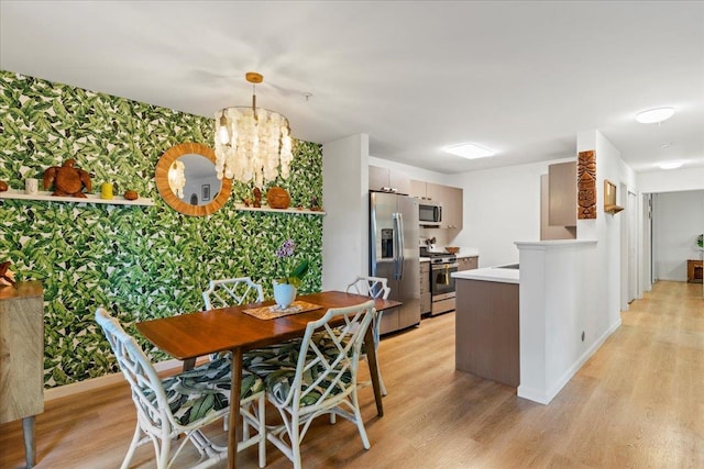 kitchen with a chandelier, light hardwood / wood-style floors, and appliances with stainless steel finishes