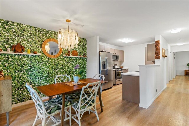 56 Kihalani St Unit 1203, Kihei, HI 96753 - dining room featuring wallpapered walls, light wood-style flooring, a chandelier, and baseboards