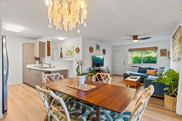 dining room featuring a wall unit AC, ceiling fan, light hardwood / wood-style flooring, and sink