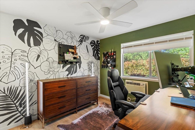 office area with light wood-type flooring, a wall unit AC, and ceiling fan