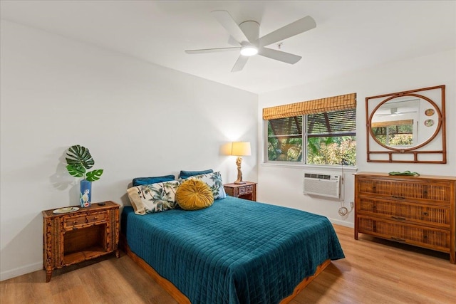 bedroom featuring ceiling fan, light hardwood / wood-style floors, and an AC wall unit