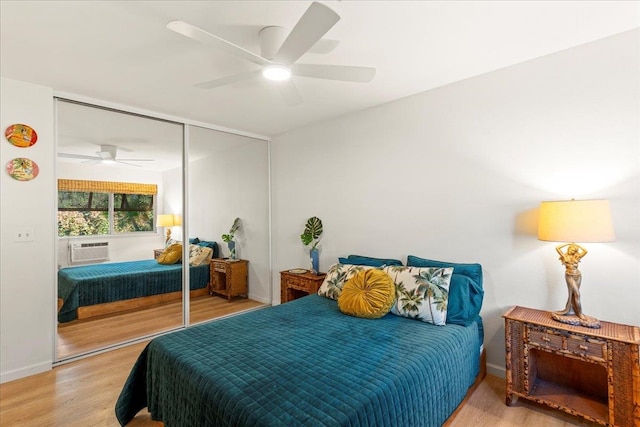 bedroom featuring a wall mounted air conditioner, ceiling fan, light hardwood / wood-style flooring, and a closet