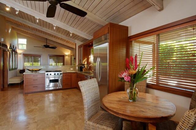 kitchen with beam ceiling, kitchen peninsula, sink, premium appliances, and wooden ceiling