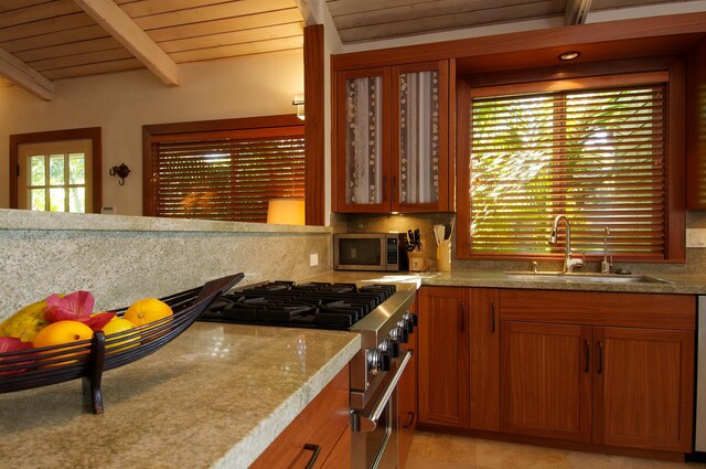 kitchen with wood ceiling, appliances with stainless steel finishes, tasteful backsplash, sink, and beamed ceiling