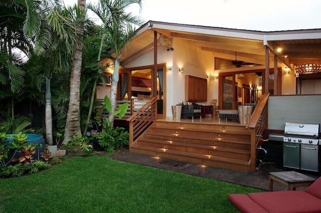 view of yard featuring ceiling fan and a deck