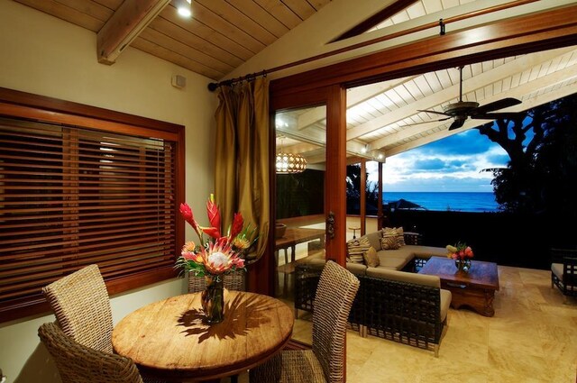 dining space featuring ceiling fan, wooden ceiling, a water view, and vaulted ceiling with beams