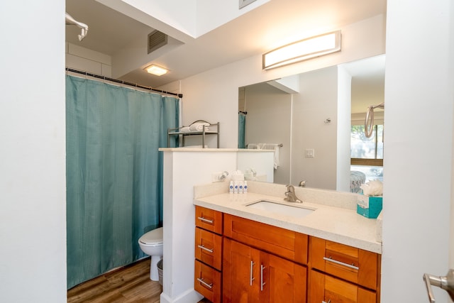 bathroom featuring vanity, hardwood / wood-style flooring, toilet, and curtained shower