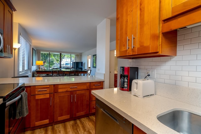 kitchen with tasteful backsplash, light stone counters, electric range, light hardwood / wood-style flooring, and dishwasher