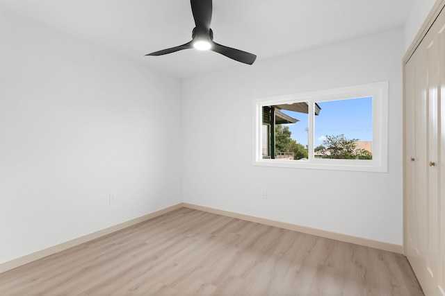 empty room featuring light wood-style floors, baseboards, and ceiling fan