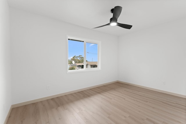 spare room with wood finished floors, baseboards, and a ceiling fan