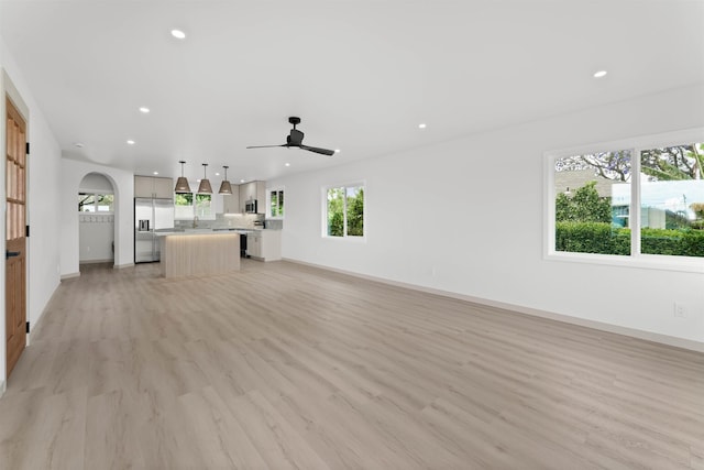 unfurnished living room with recessed lighting, light wood-style flooring, baseboards, and ceiling fan