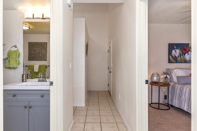 hallway featuring sink and light tile patterned flooring