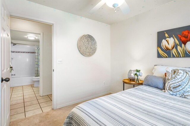 bedroom with ceiling fan, light tile patterned floors, and ensuite bathroom