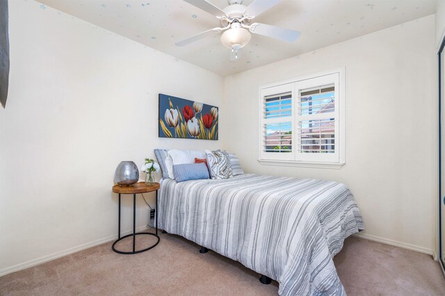 bedroom with ceiling fan and light carpet