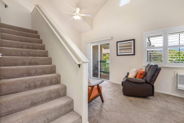 staircase featuring ceiling fan, high vaulted ceiling, and carpet