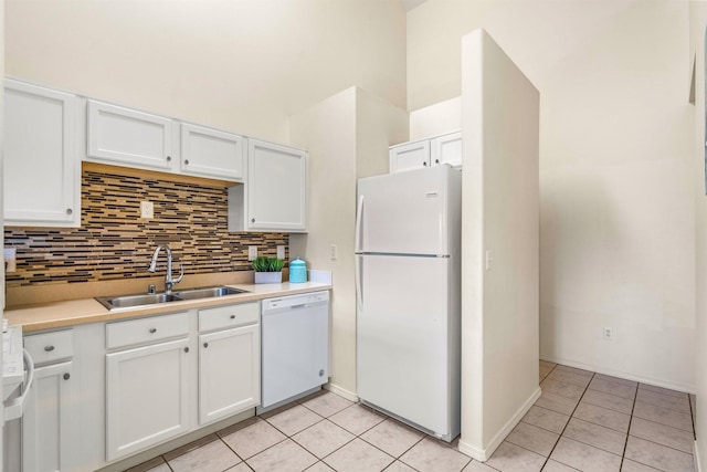 kitchen featuring white cabinetry, sink, white appliances, and backsplash