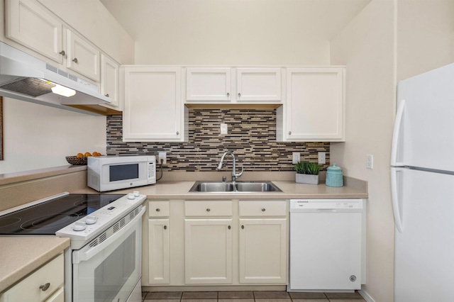 kitchen featuring white appliances, white cabinets, tasteful backsplash, sink, and light tile patterned floors