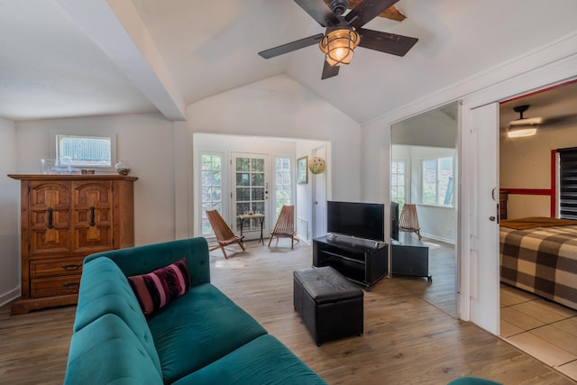 living room with ceiling fan, wood-type flooring, lofted ceiling, and a healthy amount of sunlight