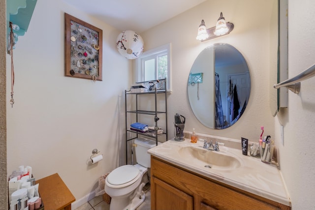 bathroom with toilet, vanity, and tile patterned flooring