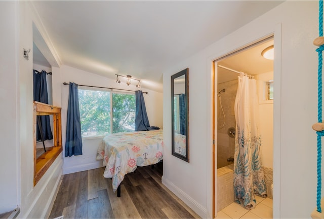 bedroom featuring hardwood / wood-style floors and lofted ceiling