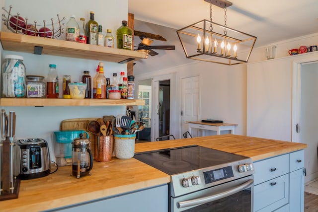 kitchen featuring electric range, pendant lighting, and butcher block countertops