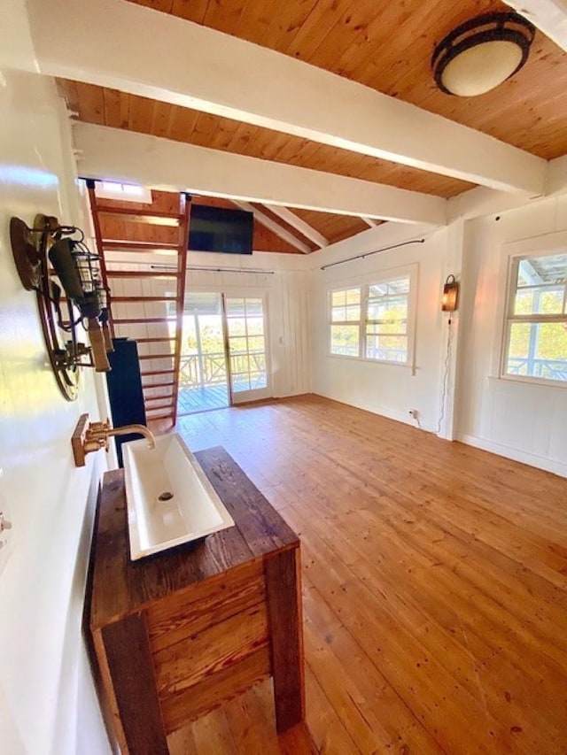 unfurnished living room with wooden ceiling, vaulted ceiling with beams, and hardwood / wood-style flooring