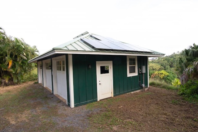 view of outbuilding featuring solar panels