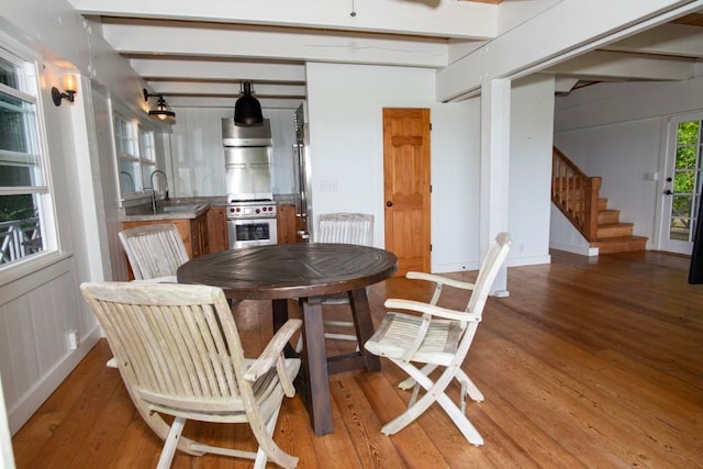 dining room featuring light wood finished floors and stairway