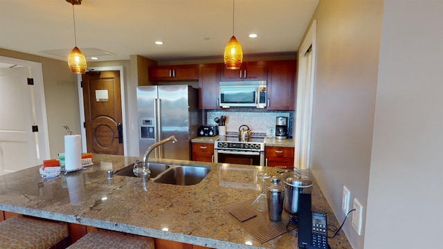 kitchen with decorative backsplash, pendant lighting, light stone counters, sink, and high quality appliances