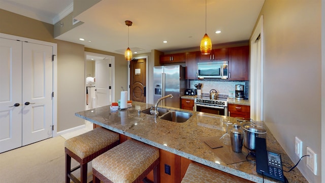 kitchen with sink, decorative backsplash, pendant lighting, and high end appliances