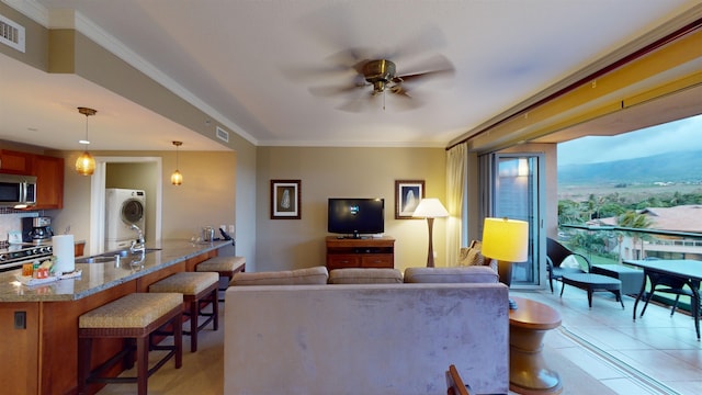 living room featuring ceiling fan, light tile patterned floors, sink, and crown molding