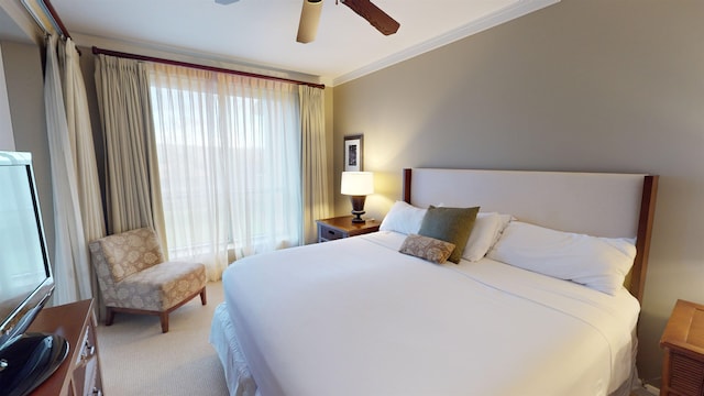 carpeted bedroom with ceiling fan and crown molding