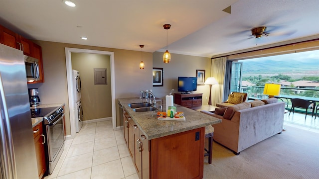 kitchen featuring stainless steel appliances, stacked washing maching and dryer, sink, ceiling fan, and light carpet